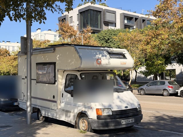 Älteres Wohnmobil am Straßenrand vor modernen Wohnanlagen in Nou Llevant, Palma