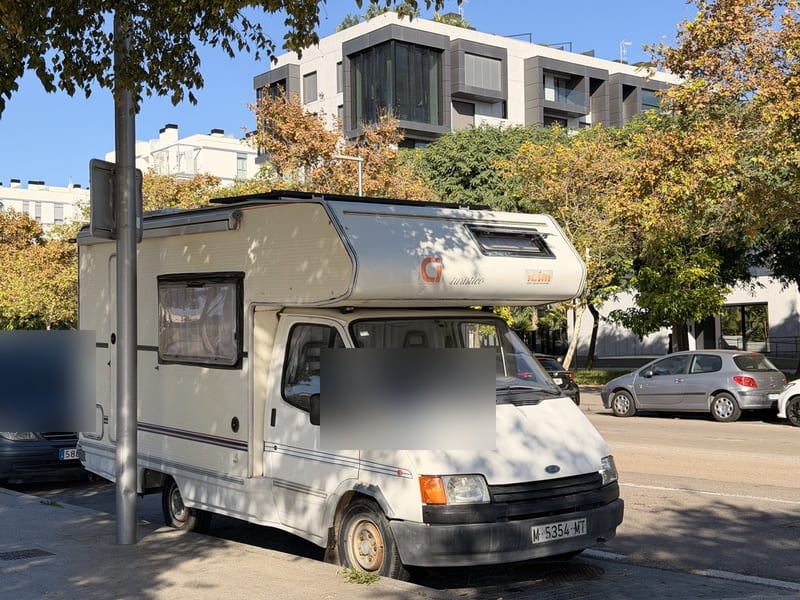Älteres Wohnmobil am Straßenrand vor modernen Wohnanlagen in Nou Llevant, Palma