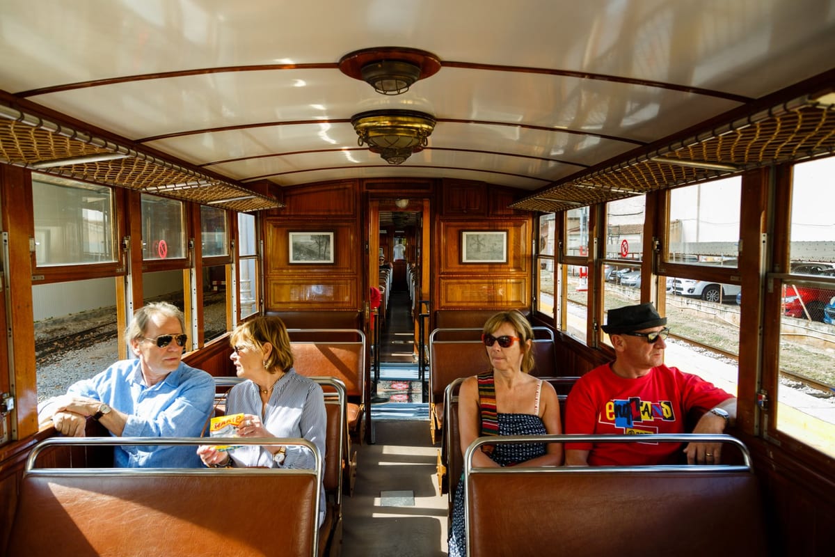 Fahrgäste im holzvertäfelten Waggon des historischen Zugs Tren de Sóller
