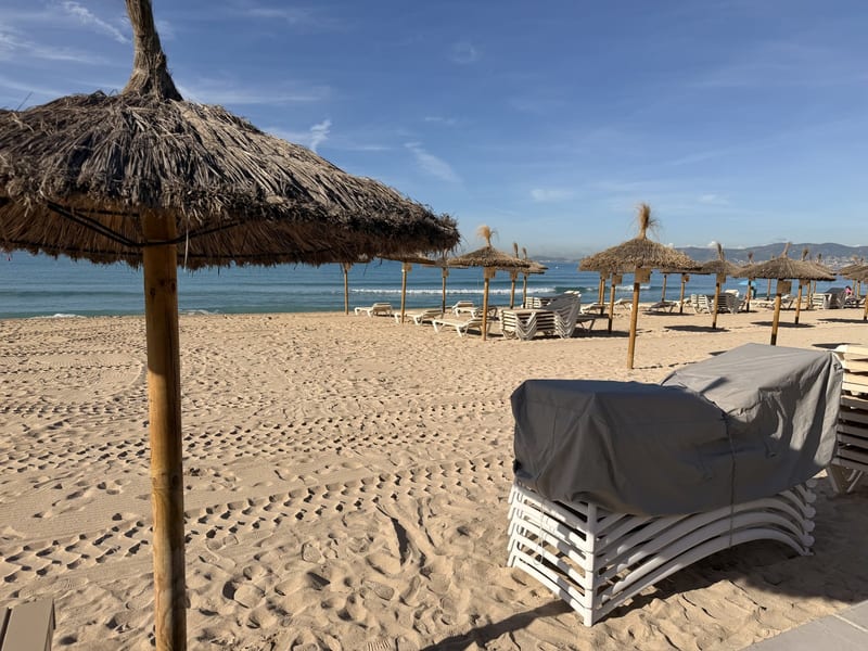 Gestapelte Liegen unter einer Plane am leeren Strand der Playa de Palma im Herbst