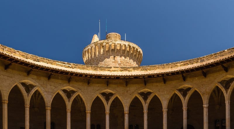 Runder Innenhof des Castell de Bellver in Palma mit zweistöckigen Arkaden und Turm