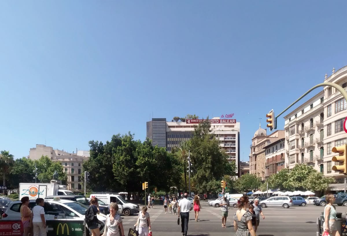 Plaça d'Espanya in Palma mit Fußgängern, Ampeln und Verkehr an einem sonnigen Tag