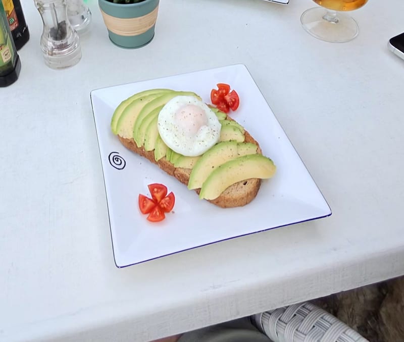 Avocado-Toast mit pochiertem Ei und Cherrytomaten beim Brunch in Freddy’s Beach Bar in Bendinat