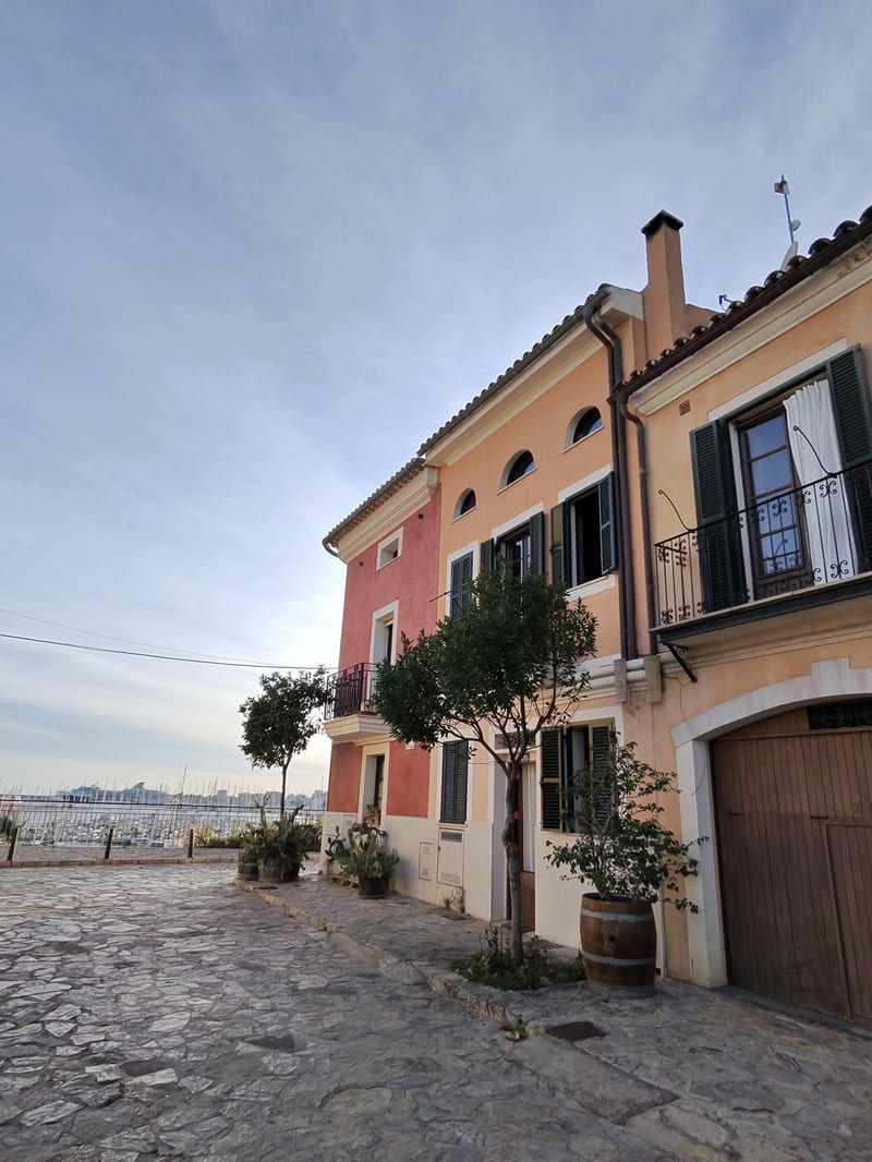 Bunte Häuser in einer Gasse von Santa Catalina, am Ende der Blick auf den Hafen von Palma